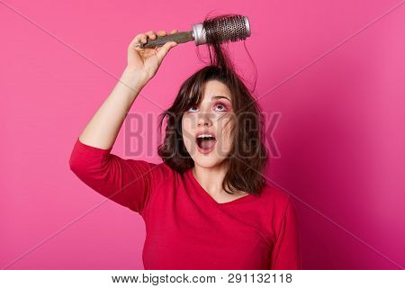 Adorable Woman With Brown Tangled Hair Tries To Comb Hairs, Looks Up, Wants To Blow Out Comb And Doi