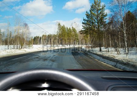 View Of The Road Through The Windshield. Snow On The Sidelines. Wet Asphalt Road. Blue Sky With Clou