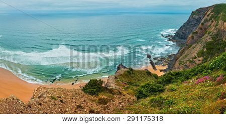 Sandy Beach With Stony Ridges Overcast Weather View On Summer Atlantic Rocky Coast (costa Vicentina,