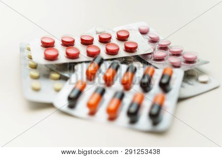 Multicolored Pills And Capsules In Blisters Close-up, On A White Background. Soft Focus. The Concept