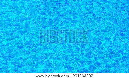 The Water Surface Of The Swimming Pool Turquoise Color, Illuminated By The Sun