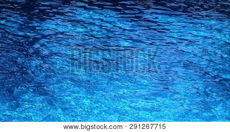 The Water Surface Of The Swimming Pool Turquoise Color, Illuminated By The Sun