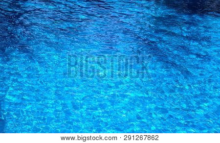 The Water Surface Of The Swimming Pool Turquoise Color, Illuminated By The Sun