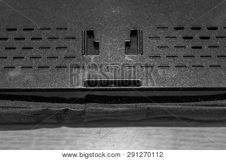 Closeup Of Holes Of Mounting Plate And Speaker In Back Of Car Navigation System.