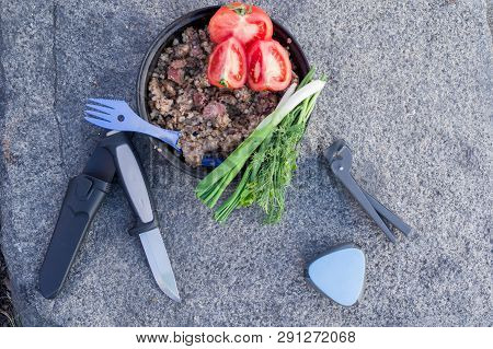 Food cooked in nature. Buckwheat porridge with meat. Vegetables and greens. Flat lay.