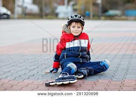 Little School Kid Boy Skating With Rollers In The City. Child In Protection Safety Clothes. Active S