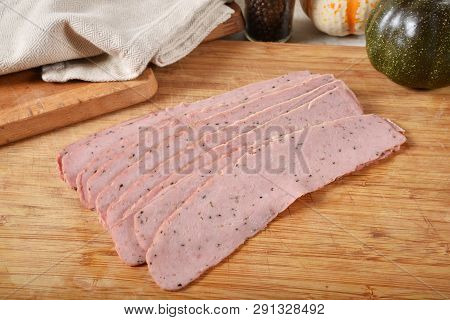Slices Of Raw, Uncured Turkey Bacon On A Wooden Cutting Board