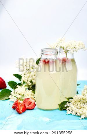 Kombucha Tea With Elderflower And Strawberry On Blue Background.