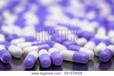 Selective Focus Purple And White Capsule Pills On Stainless Steel Drug Tray. Pile Of Capsule Pills. 