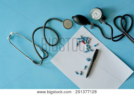 White Sheet Paper With Black Pen And Colored Different Pills.