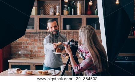 Woman Shooting Food Blogger. Photo Session. Man At Kitchen Counter With Plate Of Fresh Pastries. Hav