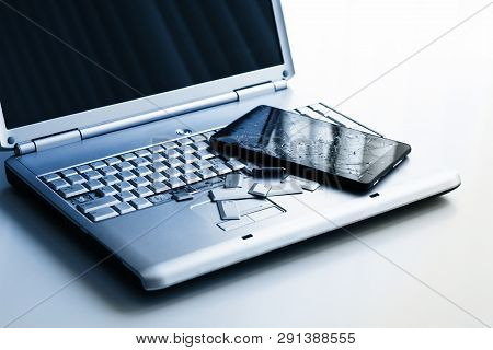 A Silver Laptop With A Broken Keyboard And A Tablet With A Cracked Display. A Close-up Picture Of Pa