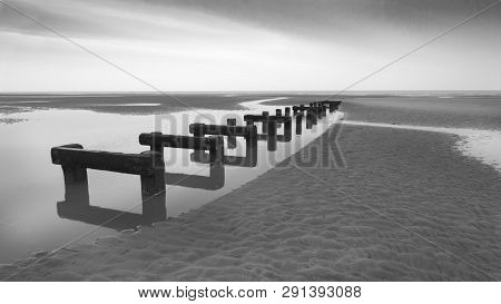 Wooden Posts In The Beach Close To The Ocen
