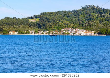 Summer Vacation Background With Turquoise Sea Water Bay And Pine Trees, Thassos Port And Town View W