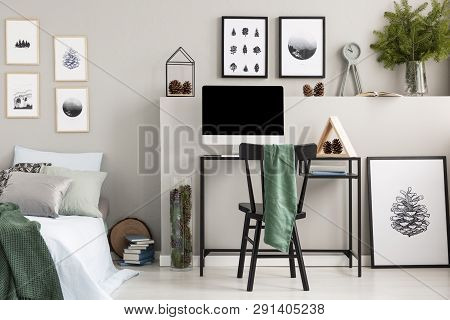 Green Cloth On Black Wooden Chair At Desk With Computer, Wooden Triangle And Cones, Real Photo With