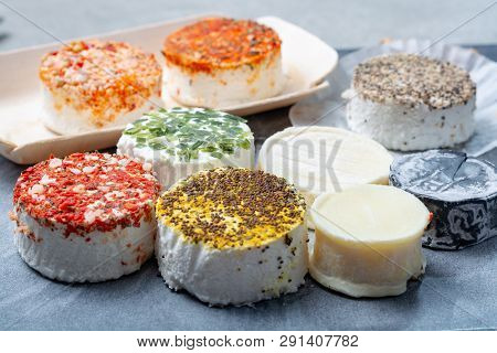 Assortment Of French Fresh White Soft Goat Cheeses With Different Tastes Topping Made With Herbs, Pa