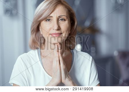 Woman 50 Or 60 Years Old Doing Yoga Folding His Hands In Front Of Him. Yoga Classes Brings Her Pleas