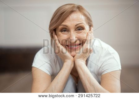 Smiling Woman After Yoga Class. A Woman Looks Older Than 50 Years. She Practices Yoga At Home. Yoga 