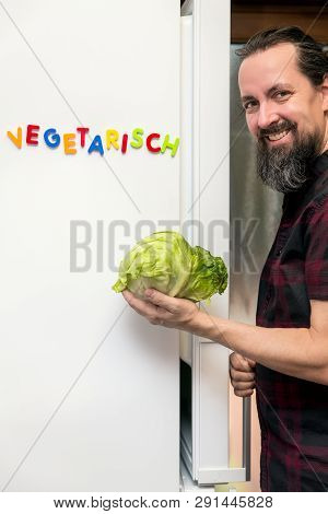 Man Holding A Salad And Opening The Fridge, German Word Vegetarisch, Which Means Vegetarian