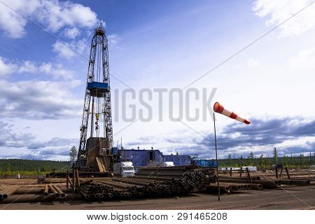 Oil And Gas Drilling Rig Onshore Dessert With Dramatic Cloudscape. Oil Drilling Rig Operation On The