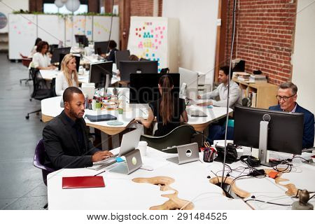 Business Team Working At Desks In Modern Open Plan Office