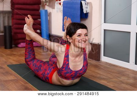 Young Sporty Woman Practicing Yoga, Doing Mahamudra Stretching Position In A Fitnes Club