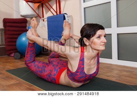 Young Sporty Woman Practicing Yoga, Doing Mahamudra Stretching Position In A Fitnes Club