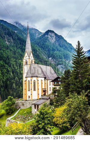 The beginning of the famous road Grossglocknerstrasse. The most beautiful village in the Alps is Heiligenblut. Gothic church of St. Vincenzo. Spring in the Austrian Alps. 