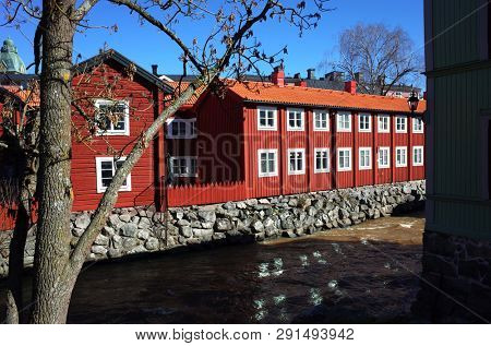 Vasteras, Sweden - 22 March, 2019: Swedish style red houses and Black river in early spring, Idyllic nordic cityscape
