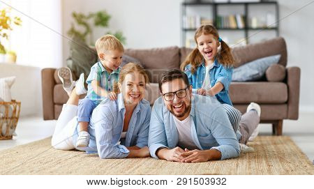 Happy Family Mother Father And Kids At Home On The Couch