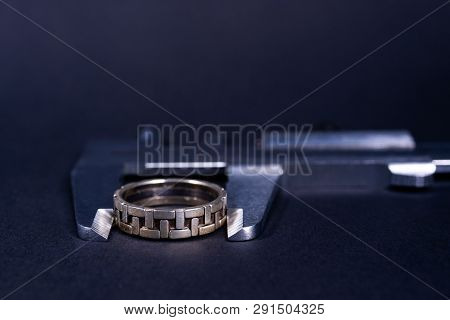 Vintage Steel Caliper Measuring Sterling Silver Male Ring Closeup. Ring In Focus. Tool In Very Good 