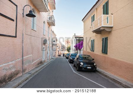 Santa Teresa Gallura, Sardinia, Italy - July 8, 2018: Sunset on Street with Car in Santa Teresa Gallura City, Sardinia, Italy. Small Street.