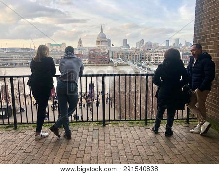 SOUTH BANK, LONDON - MARCH 23, 2019: Visitors to the Tate Modern viewing platform take in the view over the River Thames and St. Paulâs Cathedral on the South Bank in London, UK.