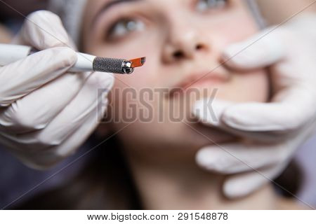 Permanent Makeup For Eyebrows. Microblading Brow. Beautician Doing Eyebrow Tattooing For Female Face