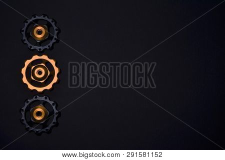 Color Rollers, Black, Golden Gears For Bicycle Rear Derailleur On Black Background In Left Side, Wit