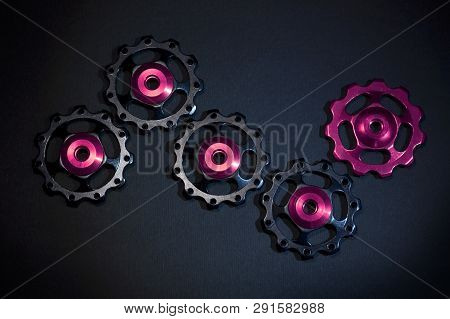 Color Rollers, Black, Purple Gears For Bicycle Rear Derailleur On Black Background