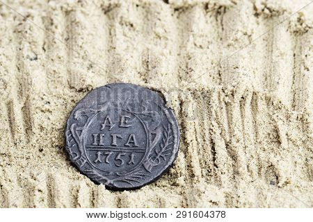 Copper Coin In The Sand With The Inscription Denga 1751 Release, Old Russian Copper Coins, Out Of Ci