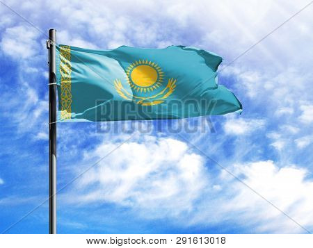 National Flag Of Kazakhstan On A Flagpole In Front Of Blue Sky.