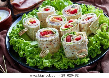 Close-up Of Sliced Sandwich Whole Grain Flatbread Wraps On A Skewers On A Plate. Ingredients And Gar