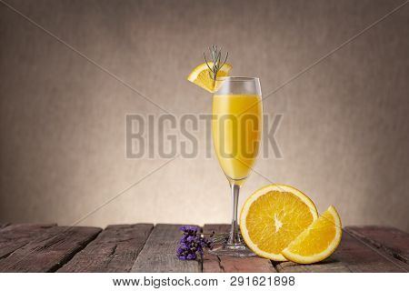 Mimosa Cocktail In Champagne Glass With Orange Juice And Sparkling Wine Decorated With Lavender Leav