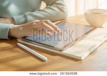 Asian Women Are Playing Tablets On The Table. Then Have A Coffee Mug