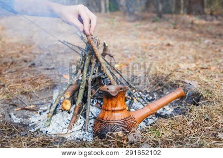 At The Stake In The Spring Forest, A Clay Turkish Coffee Pot Is Heated Against The Grass. In The Fra