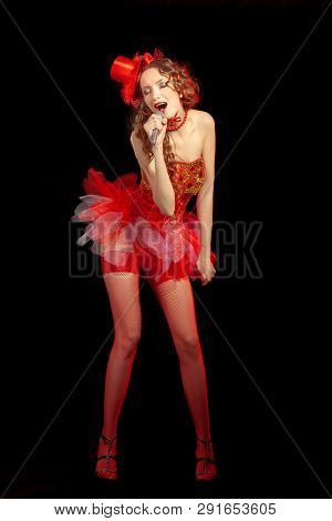 Sexy Burlesque Dancer Stripper Posing With Sweet Lollipop, In Red Corset And Red Hat With Curly Hair