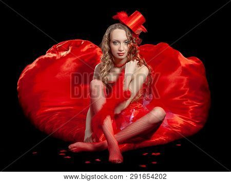 Sexy Burlesque Dancer Stripper Posing With Sweet Lollipop, In Red Corset And Red Hat With Curly Hair