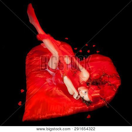 Sexy Burlesque Dancer Stripper Posing With Sweet Lollipop, In Red Corset And Red Hat With Curly Hair