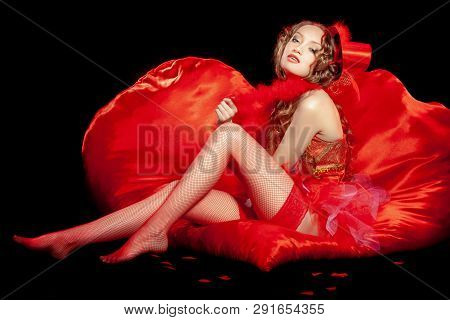 Sexy Burlesque Dancer Stripper Posing With Sweet Lollipop, In Red Corset And Red Hat With Curly Hair