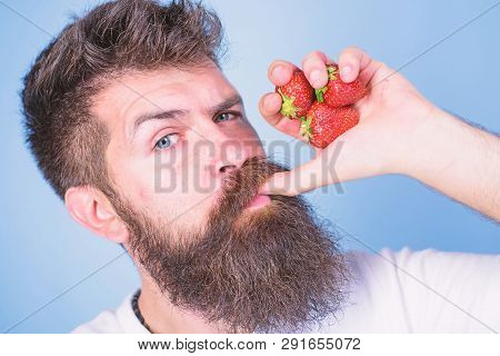 Fresh Juice Concept. Hipster Bearded Holds Strawberries Fist As Juice Bottle. Man Strict Face Enjoy 