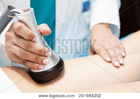 Doctor Performing An  Ultracavitation Treatment On A Young Female Patient Leg