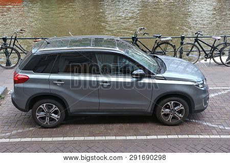Amsterdam, Netherlands - July 10, 2017: Silver Suzuki Grand Vitara Suv Parked By The Canal In Amster