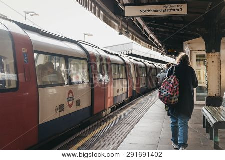 London, Uk - March 23, 2019: Woman Walking Past The Train On The Outdoor Platform Of Golders Green T